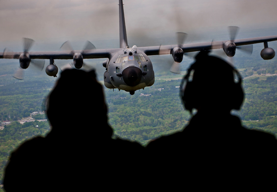 airmen looking out the back hatch at a c130