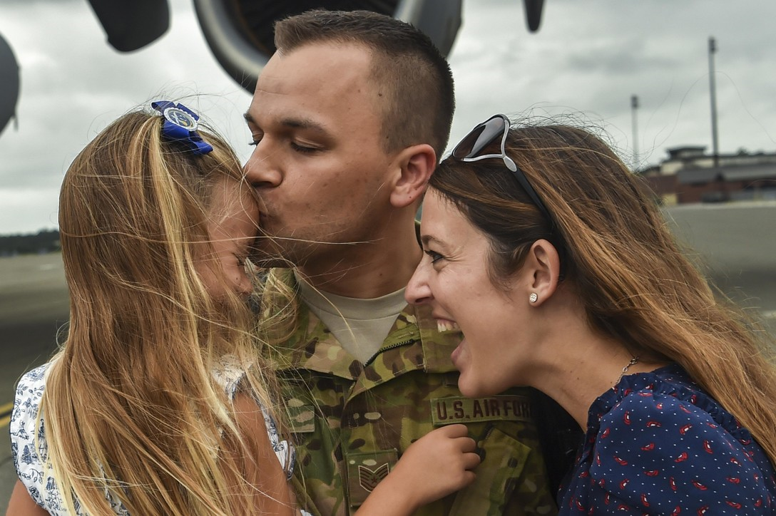 Airman hugging his family
