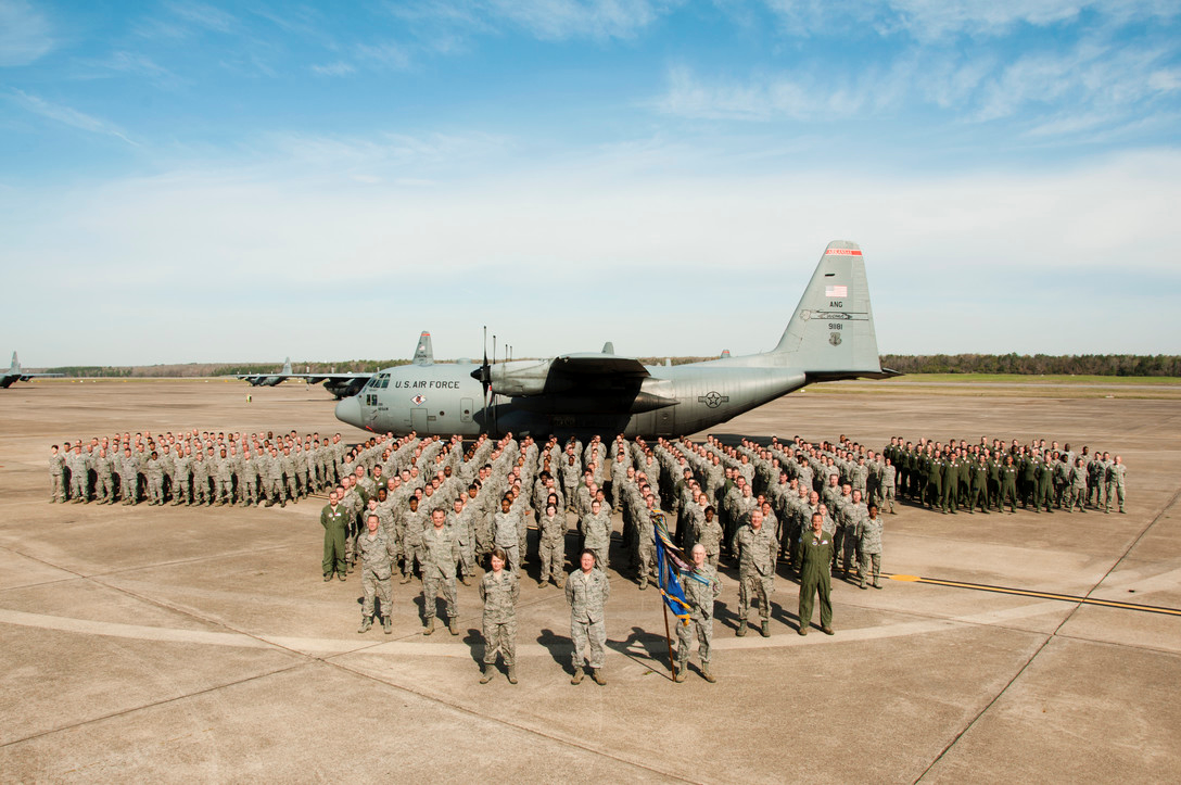 large group of Airmen standing in front of a C130