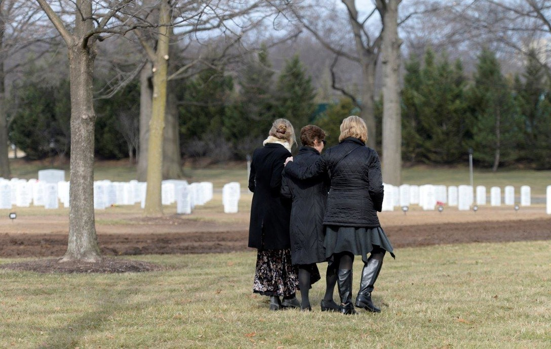 3 people walking in a veteran cemetery