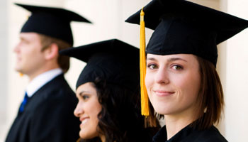 3 people in cap and gowns at a graduation ceremony