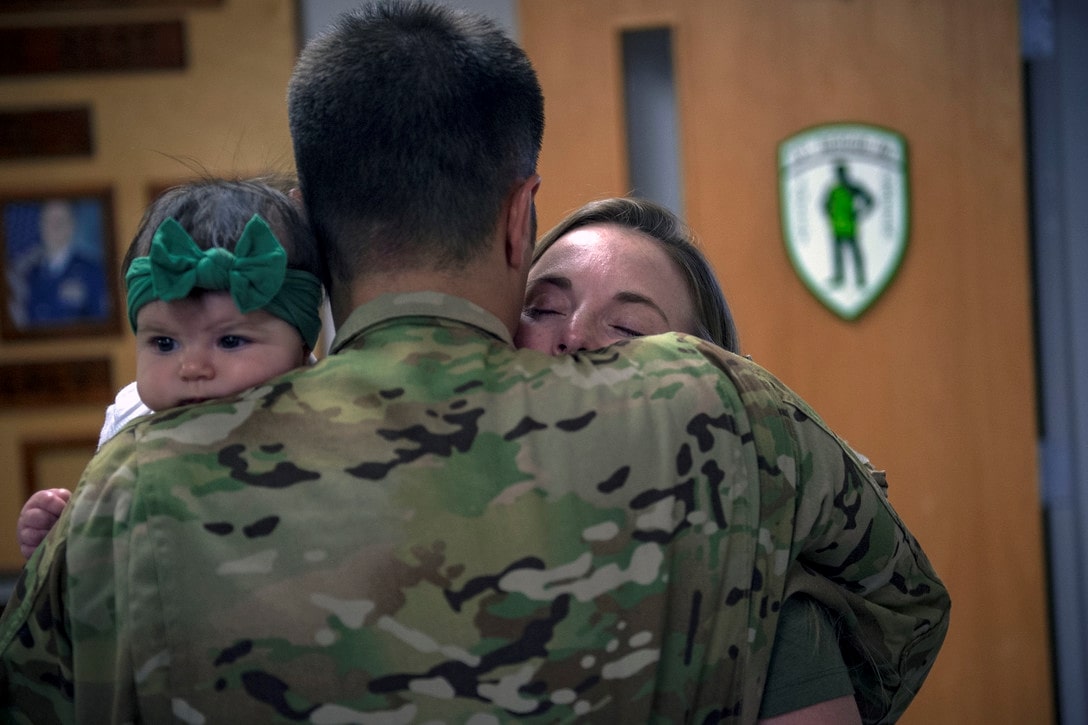 Airman and family hugging