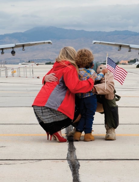 Airman hugging his family