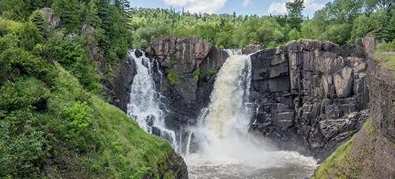 two waterfalls pouring into a river