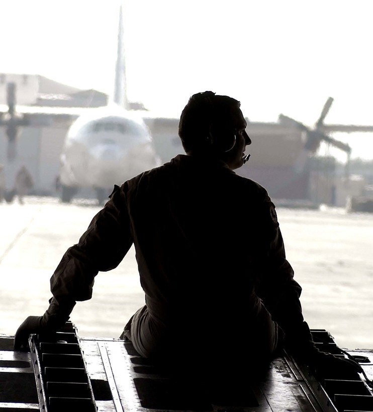 service member in the back of a cargo plane