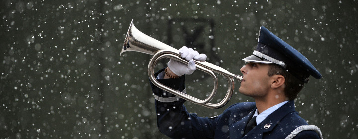 Airman with bugle playing Taps